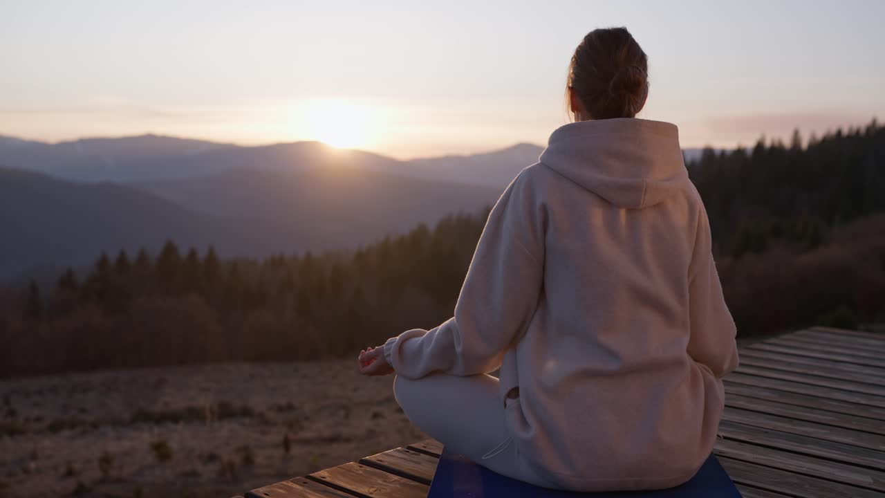 해가 지면 산에서 명상 하는 여자