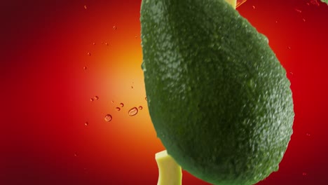 aguacate con rebanadas y salpicaduras cayendo sobre un fondo rojo