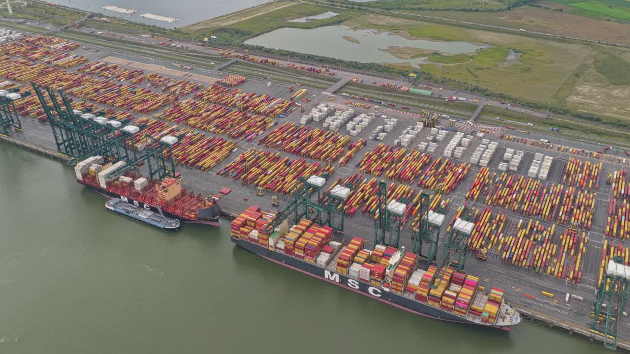 Top down view of shipping port with vessels, cranes and stacked containers
