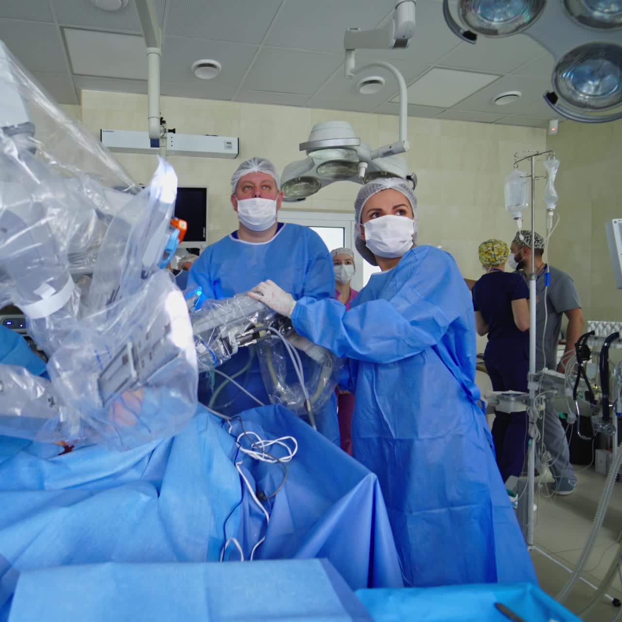 Modern medical equipment with robotic arms. Medical specialists in the operating room during cancerous tumor removal surgery with surgical robot