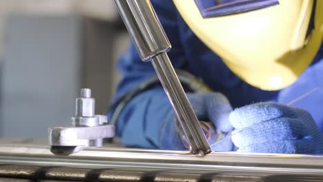 man wearing mask welding in a workshop. metal workers use manual labor. skilled welder. welder is welding the stainless steel pipes in the factory. welder industrial part in factory.