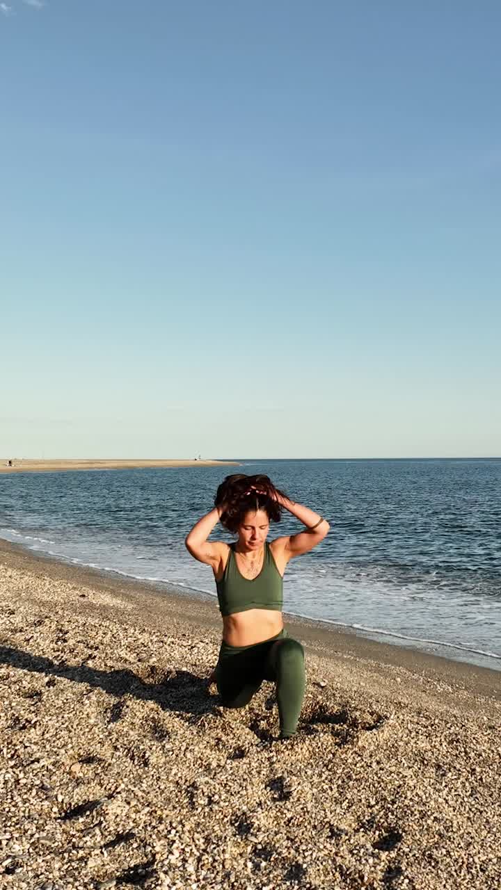 Female practicing yoga on beach with focused posture