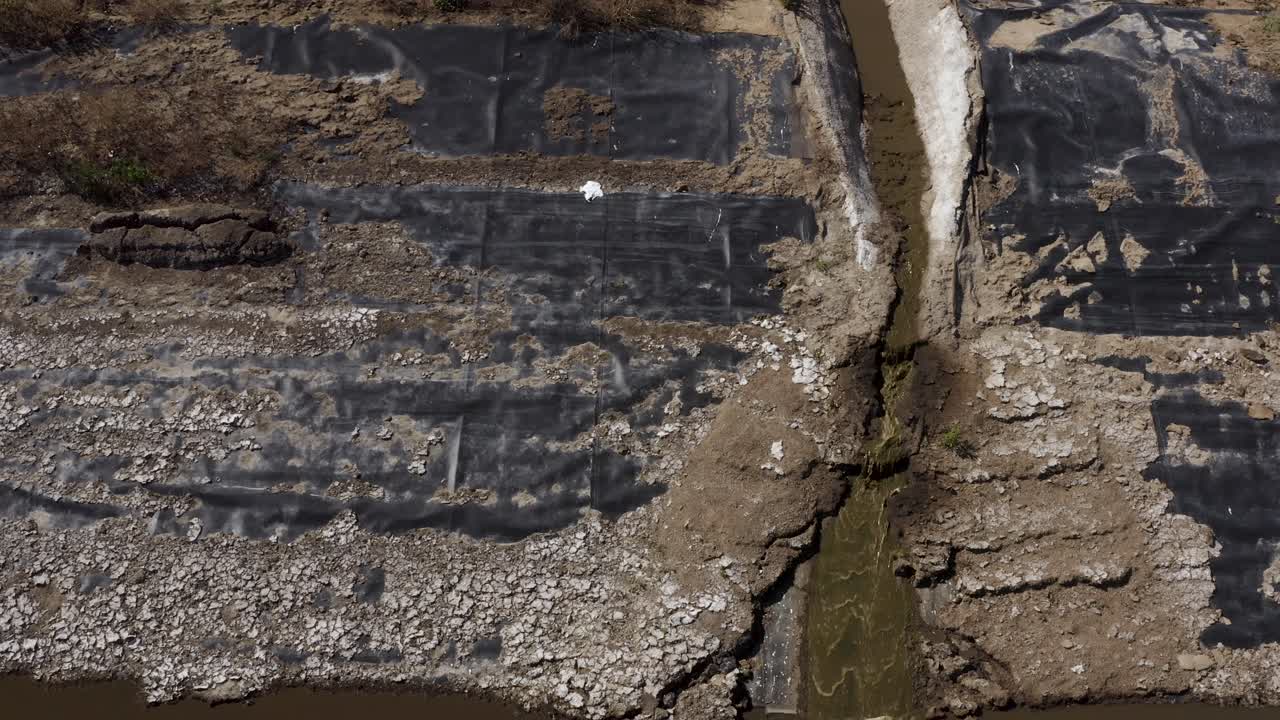 toma aérea de una laguna de estiércol sobre un pico de flujo que drena hacia la siguiente celda