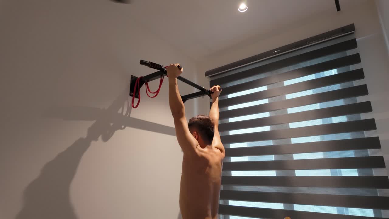 Homem fazendo barra fixa em casa com pegada neutra