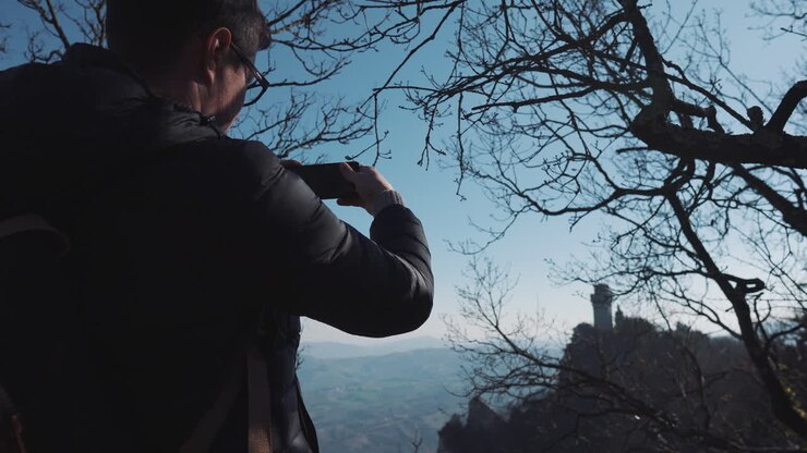 Uomo che fotografa un panorama montano