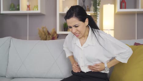 mujer que sufre de dolor abdominal severo.