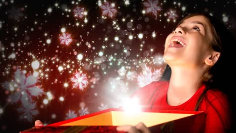 chica emocionada abriendo una caja de regalos de navidad mágica con copos de nieve brillantes