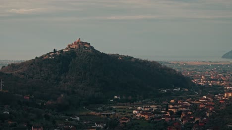 aerial ascent approaching nicola, italy, rolling hills and rustic homes under golden afternoon light, establishing overview