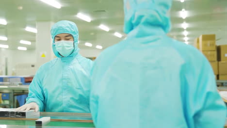 making medicine factory, medical staff in protective uniform work using tablets to walk and communicate with pharmaceutical facilities at drug manufacturing plant