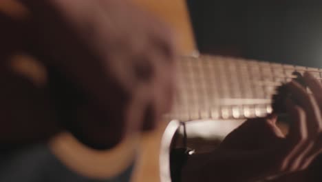 a handsome guy plays an acoustic guitar in an abandoned cinema. the musician sings a song and accompanies on the guitar