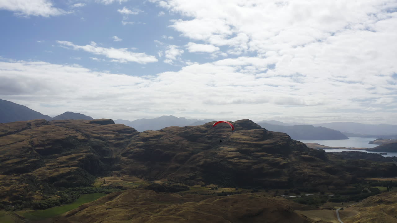와나카 뉴질랜드에서 마운트 어스파이어링 근처의 호수가 내려다보이는 산과 언덕을 통과하는 패러글라이딩