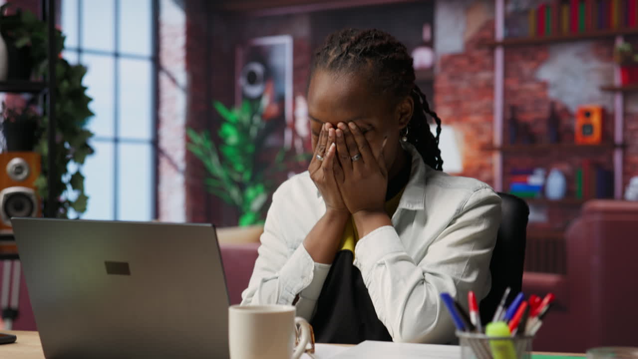 Tired teleworker yawning while typing on notebook keyboard
