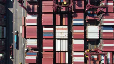 large shipping containers are seen stacked tightly together at a bustling port. cranes are actively loading and unloading cargo, showcasing efficient logistics in action.
