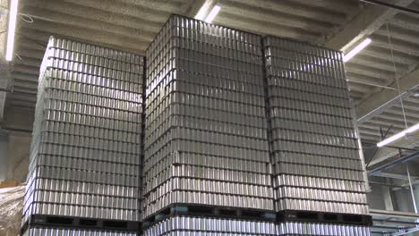 stacked pallets of empty aluminum beer cans in brewery warehouse