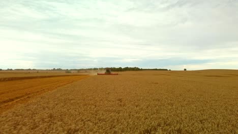 combine harvester in operation during summer drone point of view