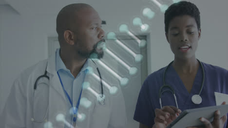 animation of dna strand over african american female and male doctor with tablet talking in hospital