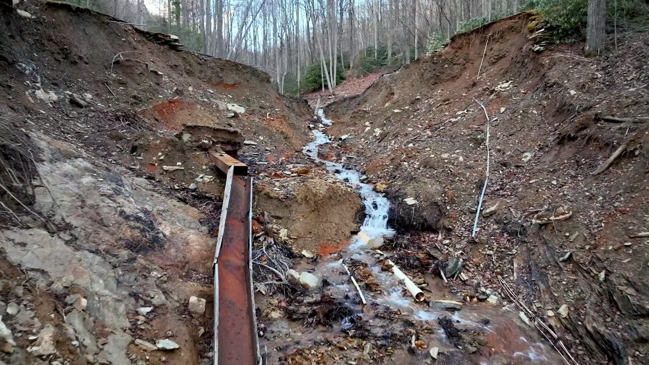 low angle of earthen dam break on pond during hurricane helene near boone nc