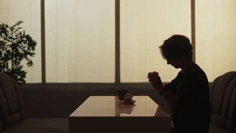 person sitting at table, enjoying coffee and cake