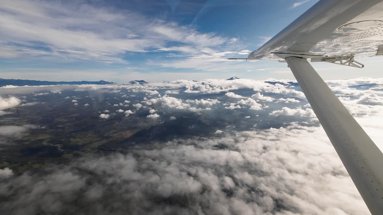 POV lille fly flyver over vildmark med bjerge og skyer, bushflyvning