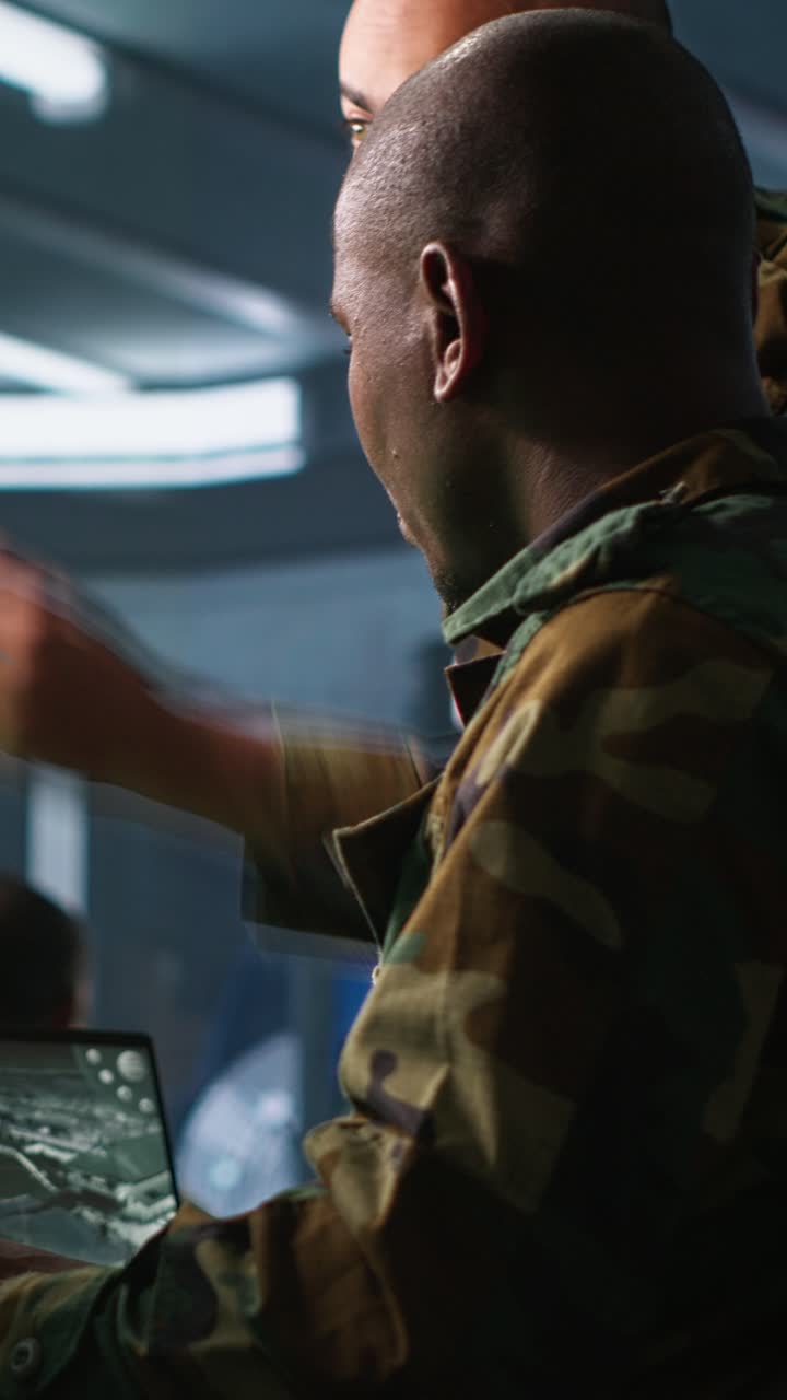 Vertical video Experts using tracking gear and radar systems in command center