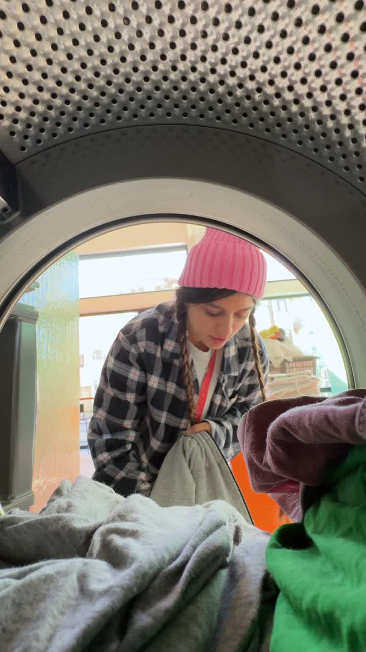 Person loading washing machine with clothes