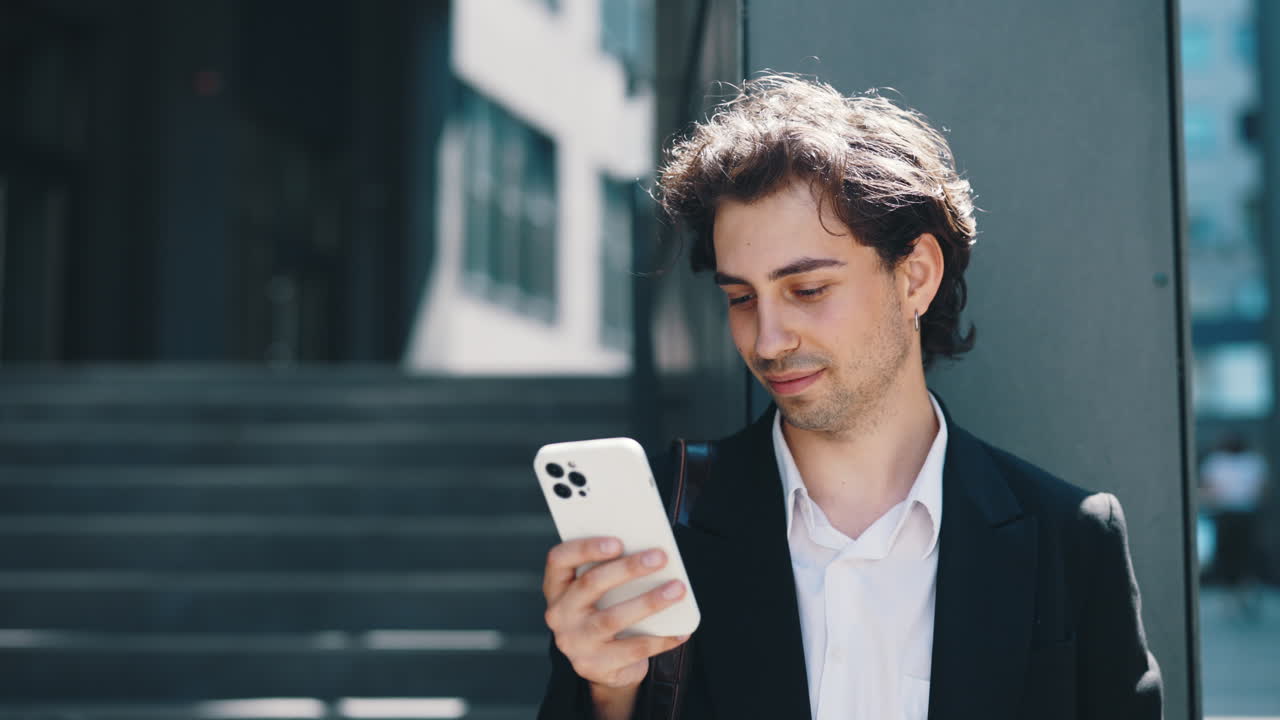 밖에서 스마트폰을 사용하는 젊은 남자