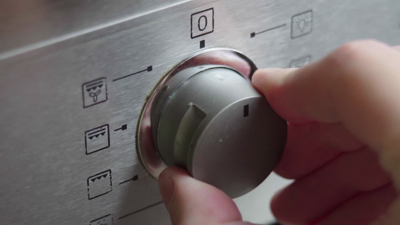 요리 오븐의 금속 전환 스위치 근접. 현대 오븐의 전면 패널. 스토브, 베이킹 오븐을 켜고 식사를 미리 가열하고 조리하기 위해 모드를 변경합니다.