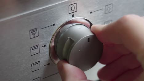 interruptor de conmutación metálico del horno de cocción de primer plano. panel frontal del horno moderno. encendiendo la estufa, horno de horneado y cambiando los modos para precalentar y cocinar la comida