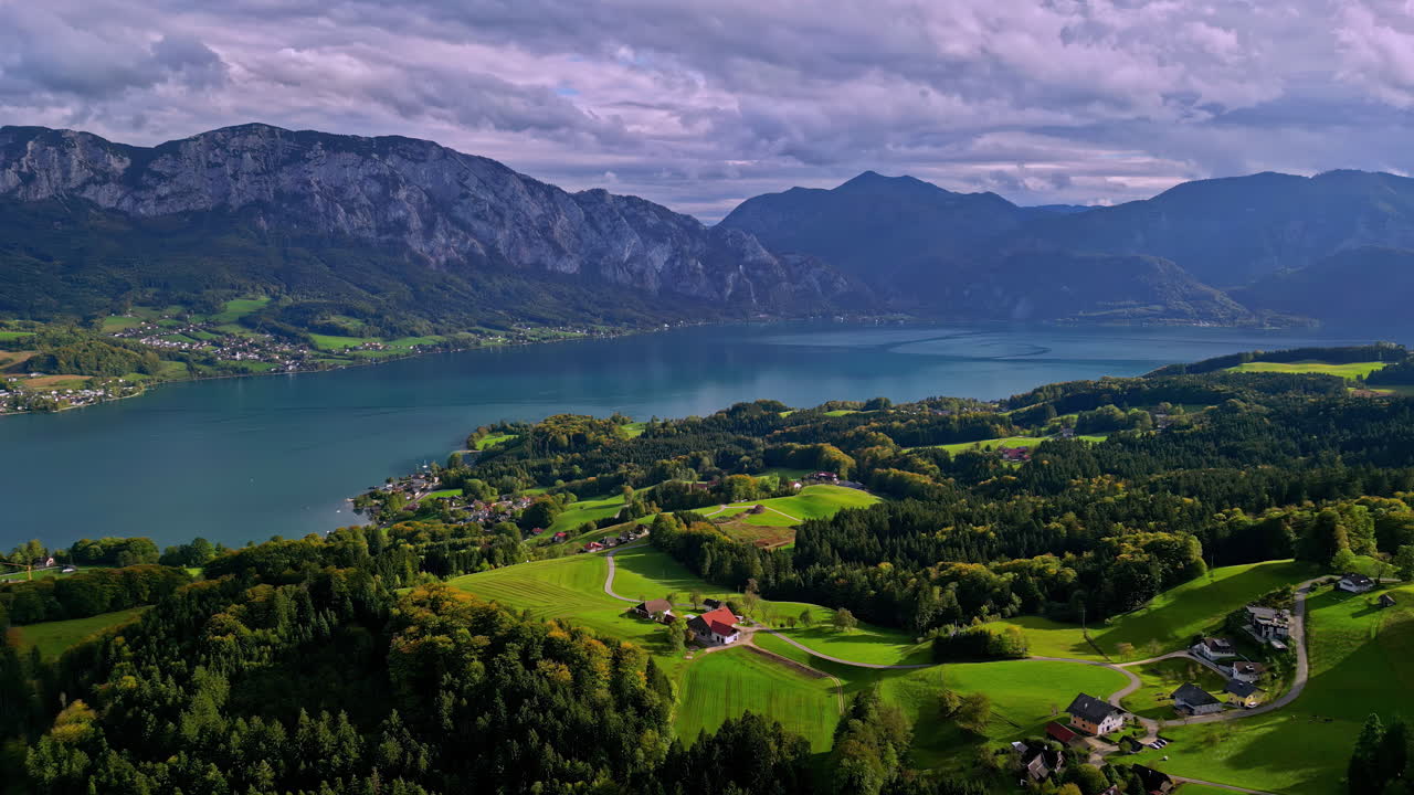 Vista drone del lago limpido in Austria in una giornata di sole con le Alpi sullo sfondo