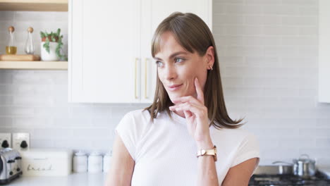 Middle-aged-Caucasian-woman-ponders-in-a-modern-kitchen