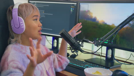 Mujer-Comiendo-Bocadillos-Mientras-Juega-En-Casa-Sentada-En-El-Escritorio-Usando-Auriculares-Para-Transmitir-En-Vivo