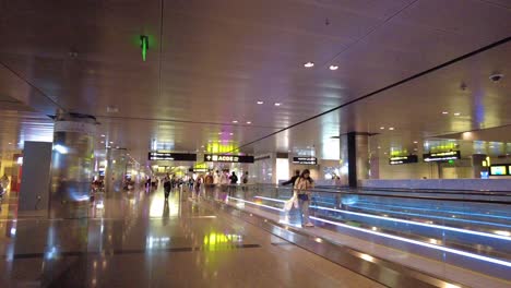 airport terminal interior with people and moving walkways