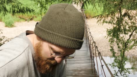 man with beard on a wooden bridge