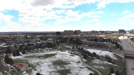 A-descending-drone-shot-showing-a-busy-Denver-freeway-and-surrounding-area