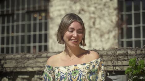 Young-caucasian-woman-laughs-outdoors-on-sunny-day