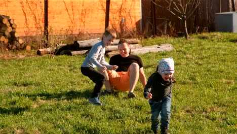 dad's playing with his son and daughter in the backyard.