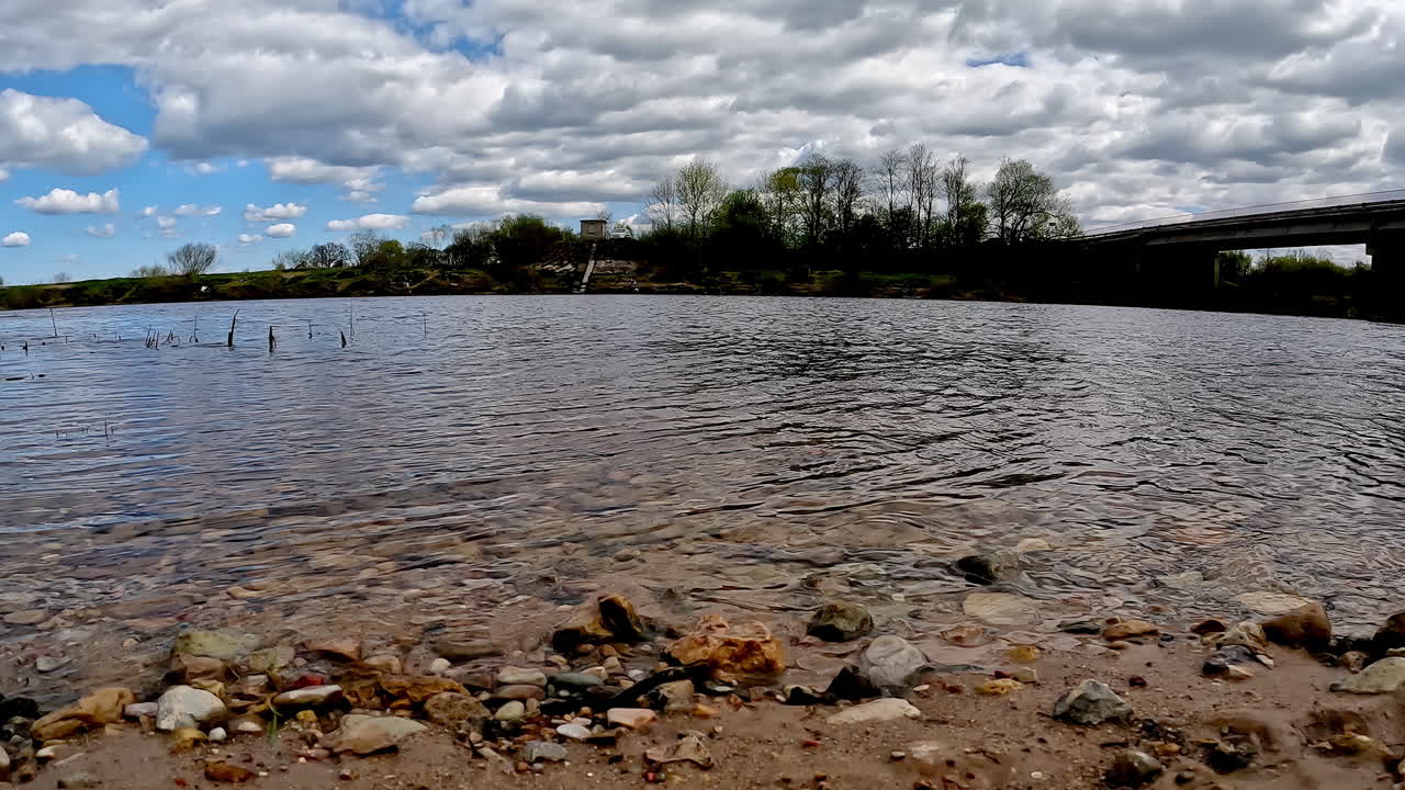 하천 의 물 이 구름 이 많은 날 에 모래 에 있는 하천 의 바위 를 부드럽게 만지며, 타임  ⁇ 스