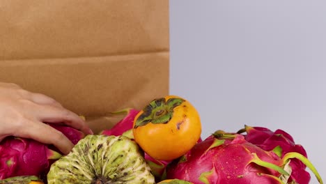 colocando frutas a mano en una bolsa de papel