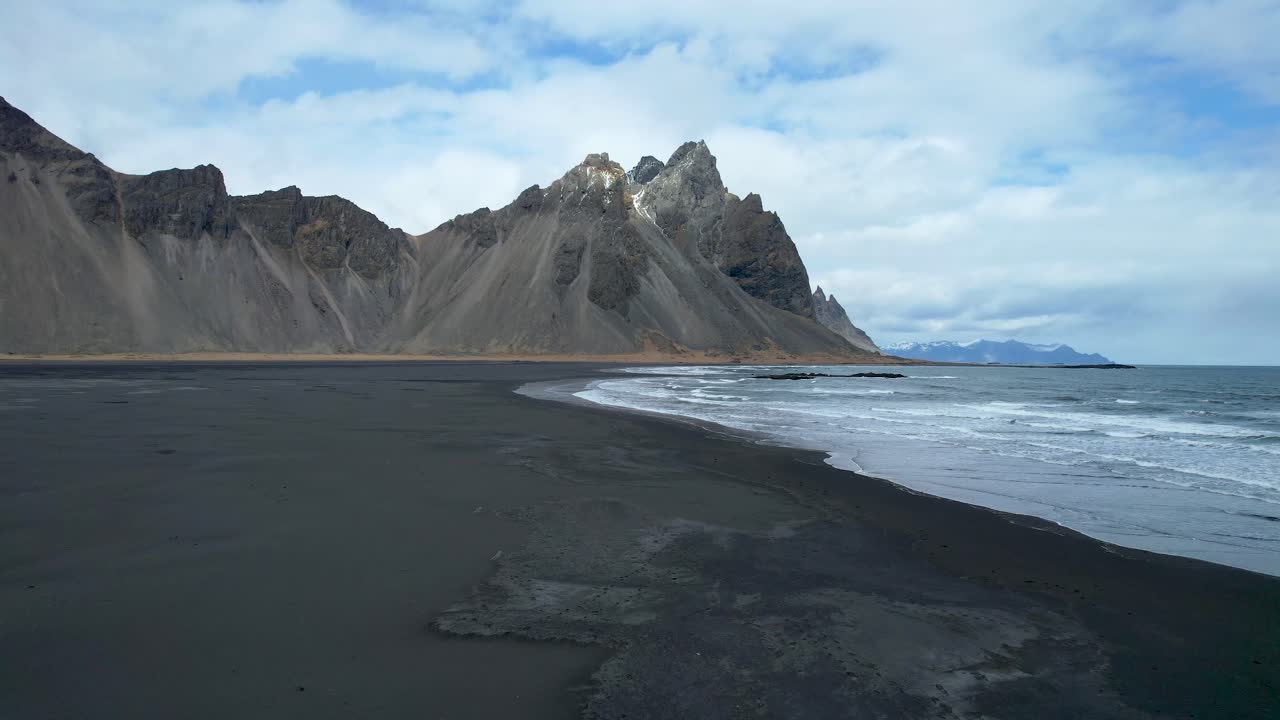 islandia drone sobre playa de arena negra con olas rompiendo en la orilla