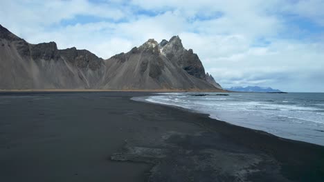 Iceland-Drone-over-black-sand-beach-with-waves-crashing-on-shore