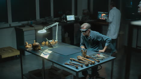 archaeologist in a lab with vr glasses, examining human remains and bones