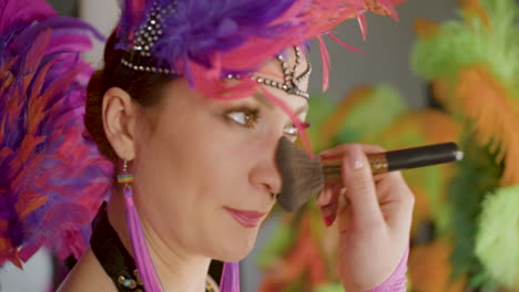 closeup view of pretty dancer in feather outfit getting ready for the show