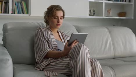 upset girl holding pad computer in living room. manager work on tablet remotely.