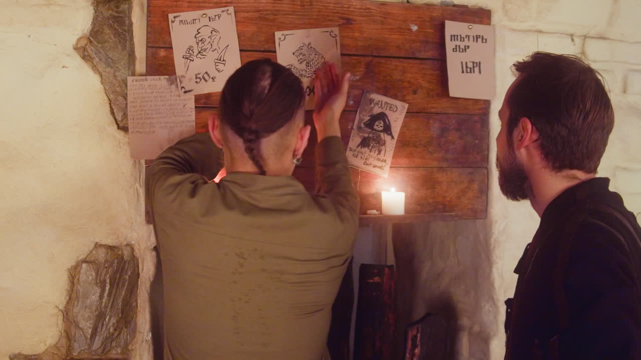 los ladrones eligen a la bestia para cazar en el tablón de anuncios en la taberna. amigos vagabundos discuten la tarea rentable en el pub medieval. los aventureros buscan un buen trabajo en el bar