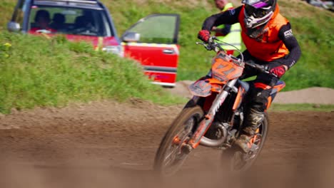 following shot of a motor cross rider diving on a bumpy off road track on a sunny day