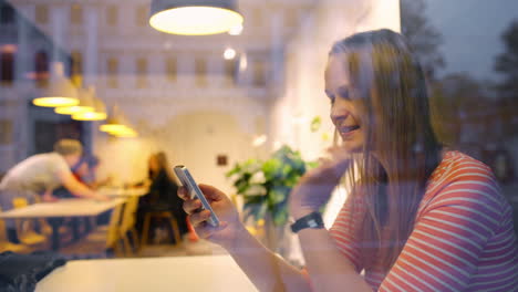 happy woman in cafe thinking over sms she typing