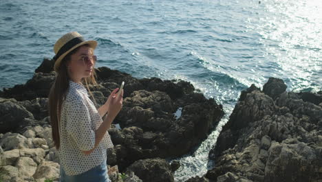 woman taking a photo on the coast