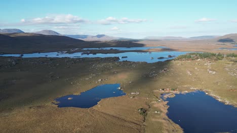 Vista-Aérea-Sobre-El-Pintoresco-Paisaje-De-Los-Lagos-De-Connemara,-Cerca-Del-Pueblo-De-Screebe,-Irlanda,-Con-Vistas-Al-Agua-Azul-Reflectante.