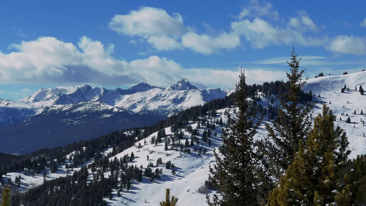 Area selvaggia del Monte Holy Cross, vetta 14er, inverno, cielo blu vivido, soleggiato, Passo Vail Colorado, ripresa aerea con drone, nuvole in movimento, neve profonda, backcountry, paesaggio naturale, Passo Ptarmigan Shrine, conca sciistica, statico.