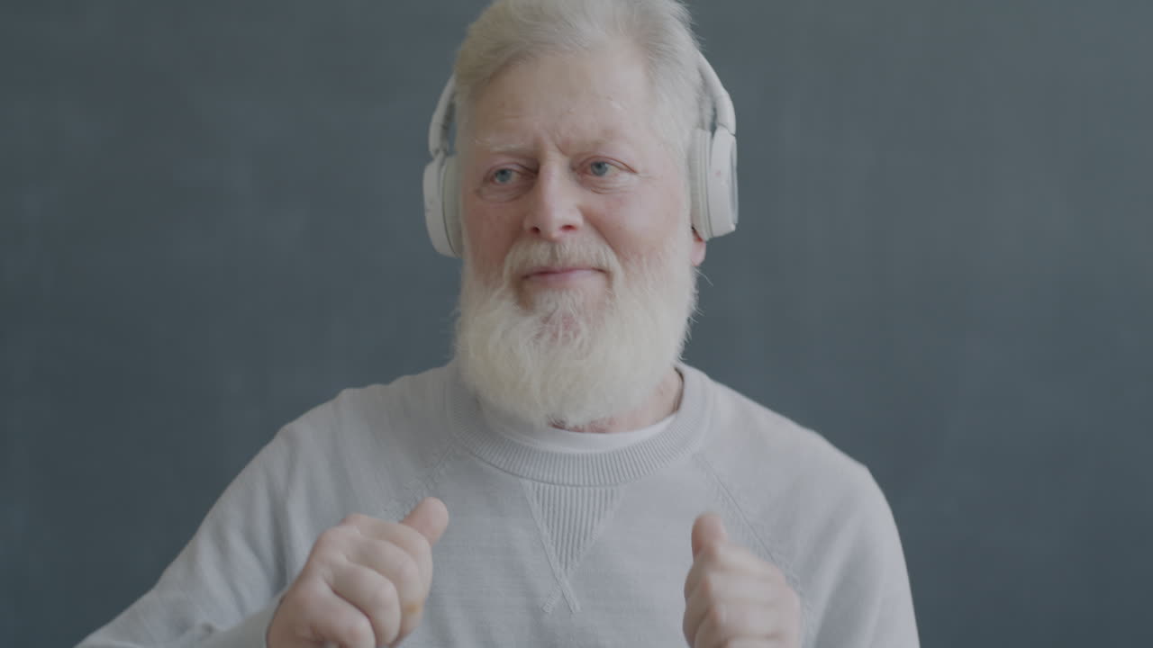 Elderly Man with Headphones Enjoying Music